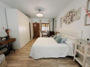 a bedroom with a large white bed and a table at SAN ISIDRO in Migueláñez