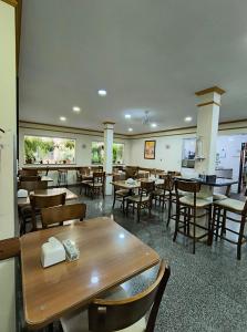 a dining room with tables and chairs in a restaurant at Hotel Graunas in São Carlos