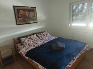 a bed in a bedroom with a picture on the wall at Apartment King in Travnik