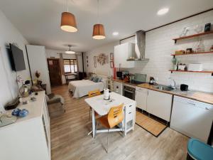 a kitchen with a table and a room with a bed at SAN ISIDRO in Migueláñez