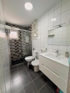 a white bathroom with a toilet and a sink at SAN ISIDRO in Migueláñez +27 photos