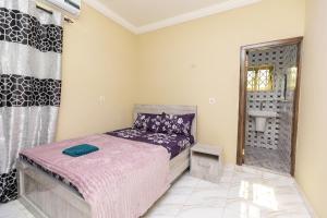 a small bedroom with a bed and a window at We care 4u lodge in Kasoa