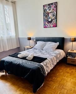 a bedroom with a bed with a painting on the wall at Le Carré Chic in Limoges