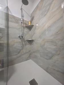 a shower in a bathroom with a stone wall at Casa Florescu in Craiova