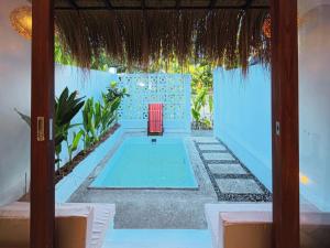 ein Zimmer mit Pool und einem roten Stuhl in der Unterkunft Casa Oro in General Luna