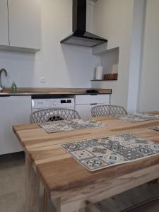 a kitchen with a wooden table with two chairs at L'écrin de Saint-pierre - Sunset & Sea View in Saint-Pierre