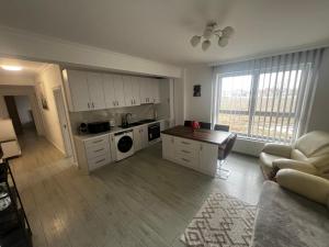 a kitchen with white cabinets and a table in a room at Dny Luxury in Rădăuţi