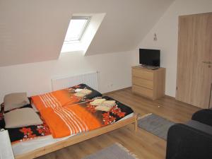a bedroom with a bed with an orange blanket at Rivendell Apartments in Prague