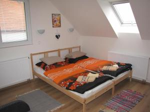 a bedroom with a bed with an orange comforter at Rivendell Apartments in Prague