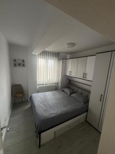 a bedroom with a bed and cabinets and a chair at Dny Luxury in Rădăuţi