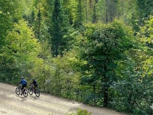 two people riding bikes down a dirt road at Chalet Le St-Ray in Saint-Raymond