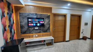 a room with a flat screen tv on a wall at 2 BHK Starry Night Penthouse in Islamabad