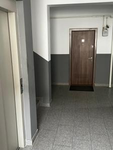 a hallway with a wooden door in a building at Dny Luxury in Rădăuţi +2 photos