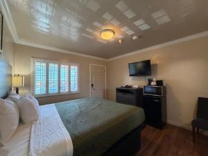 a bedroom with a bed and a tv on the wall at SurfSide Stay in Morro Bay
