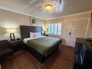 a bedroom with a bed and a tv and a door at SurfSide Stay in Morro Bay