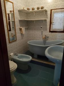 a bathroom with two sinks and a tub and a toilet at Casa Valia in Carloforte