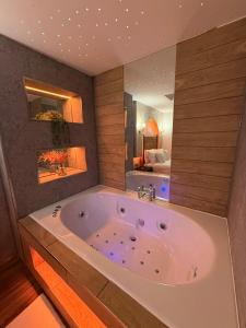 a large bath tub in a room with a bedroom at Luxury Jacuzzi Suites Halifax in Halifax