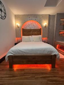 a bedroom with a large bed with a clock on the wall at Luxury Jacuzzi Suites Halifax in Halifax