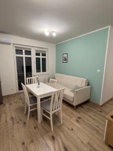 a living room with a table and chairs and a couch at Panda Apartment Plac Solny 4 z klimatyzacją in Głogów