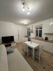 a living room with a table and a kitchen at Panda Apartment Plac Solny 4 z klimatyzacją in Głogów