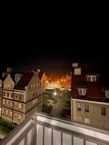 a view of a city at night from a balcony at Panda Apartment Plac Solny 4 z klimatyzacją in Głogów