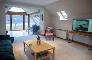 a living room with a tv and a couch and a table at Morenish Estate in Killin