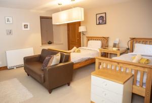 a bedroom with a bed and a couch and a chair at Morenish Estate in Killin