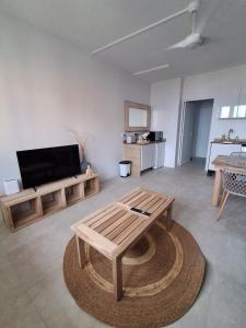 a living room with a coffee table and a flat screen tv at L'écrin de Saint-pierre - Sunset & Sea View in Saint-Pierre