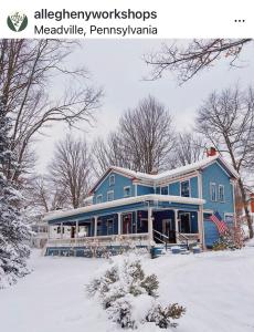 a blue house with snow on the ground at Crawford Suite in Meadville