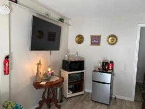 a kitchen with a small table and a television on the wall at Crawford Suite in Meadville +5 photos