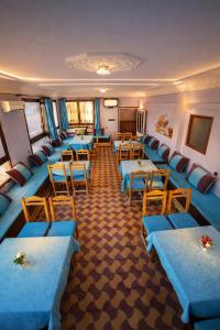 a conference room with blue tables and chairs at Hôtel Restaurant BOUGAFER in Boumalne Dades