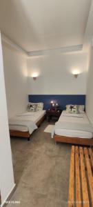 two beds in a room with blue walls at Pousada Casa da Praticagem in Salinópolis +17 photos