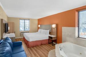 a hotel room with a bed and a bath tub at Quality Inn JFK Airport Rockaway Blvd in Queens +53 photos