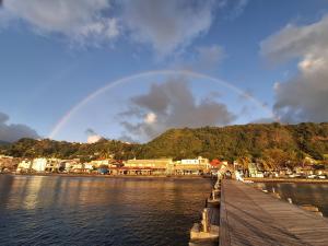 a rainbow in the sky over a body of water at L'écrin de Saint-pierre - Sunset & Sea View in Saint-Pierre