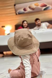 a child sitting on the floor wearing a hat at Bherunda Mount Resort in Kegalle +35 photos