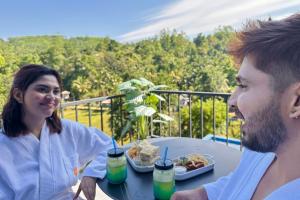 a man and woman sitting at a table with a plate of food at Bherunda Mount Resort in Kegalle