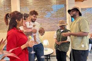 a group of people standing around a woman holding a baby at Bherunda Mount Resort in Kegalle