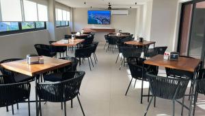 a dining room with wooden tables and chairs at Hotel Portonovo Plaza Malecon in Puerto Vallarta