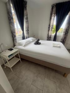 a bedroom with a bed and a table and windows at Downtown apartments in Kralendijk
