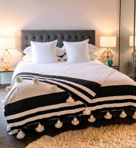 a large bed with a black and white blanket at Hôtel Restaurant BOUGAFER in Boumalne Dades