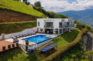 a house with a swimming pool on a hill at Glass Mansion Breathtaking 180 Panoramic View in Envigado