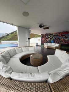 a living room with a white couch and a table at Glass Mansion Breathtaking 180 Panoramic View in Envigado