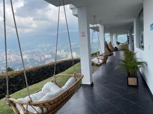 a porch with swings on a building with a view at Glass Mansion Breathtaking 180 Panoramic View in Envigado