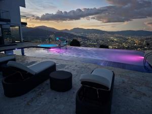 a swimming pool with a view of a city at night at Glass Mansion Breathtaking 180 Panoramic View in Envigado