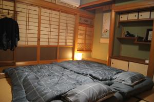 a large blue bed in a room with a wall at sakurazaka in Tanabe