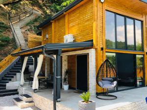 a house with a porch with a swing at Lake house Emerald in Jablanica +12 photos
