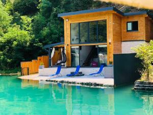 a house with chairs sitting on a dock in the water at Lake house Emerald in Jablanica