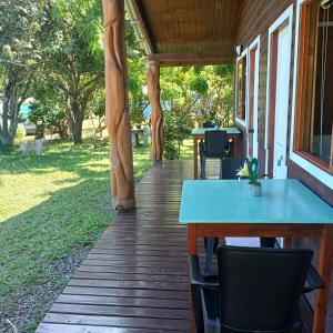a wooden porch with a blue table and chairs at Merahi House Cabañas I in Hanga Roa