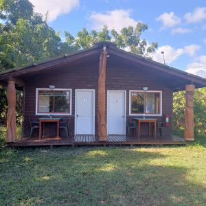 a small cabin with two tables on a deck at Merahi House Cabañas I in Hanga Roa