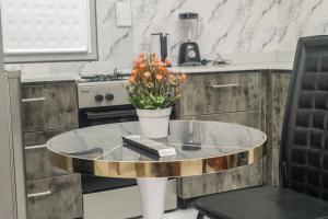 a table with a vase of flowers on it in a kitchen at We care 4u lodge in Kasoa +40 photos